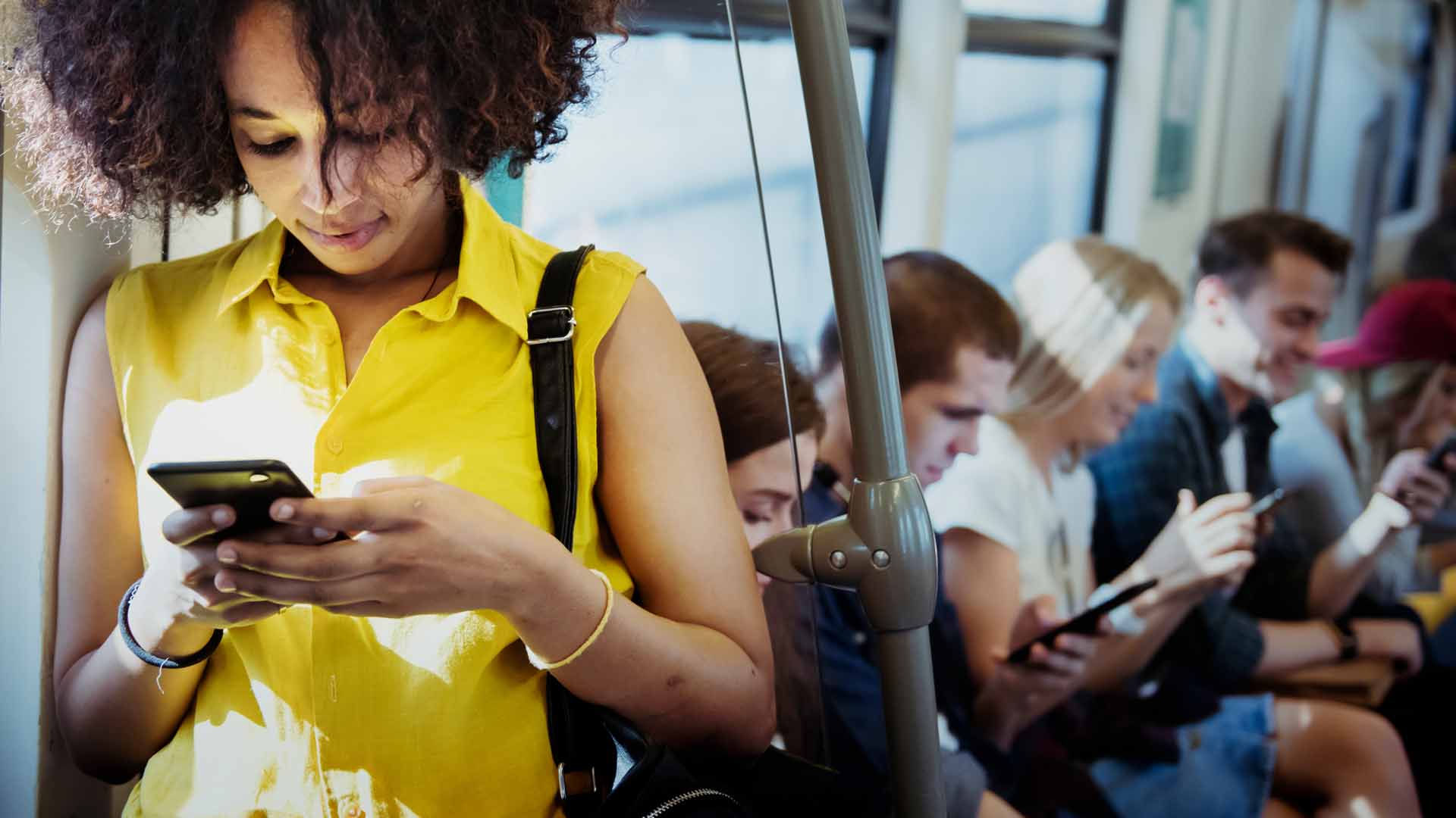 image of people messaging on a bus